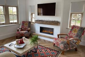 a living room with two chairs and a fireplace at Ullswater - Stunning home with breathtaking views in Dockray