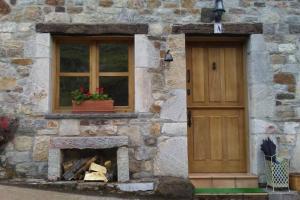 a stone house with a fireplace and a window at La Osera del Coto in El Coto