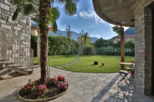 a palm tree in a garden with flowers at Hotel Elvezia in Cannobio