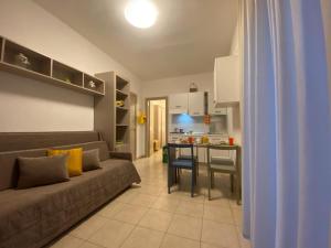 a living room with a couch and a kitchen at Primavera Club - Hotel Residence in Santa Maria del Cedro