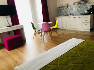 a living room with chairs and a table and a kitchen at Colors Boutique in Obzor