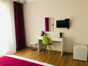 a bedroom with a desk and a green chair at Colors Boutique in Obzor