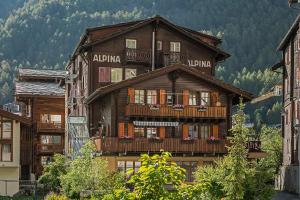 een groot houten gebouw met balkons erop bij Hotel Alpina in Zermatt