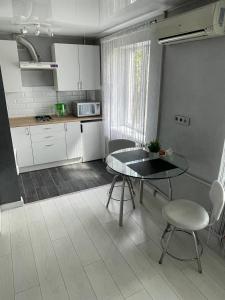 uma pequena cozinha com mesa e cadeiras num quarto em Люкс в центре Гагарина 72 Автовокзал em Krivoy Rog