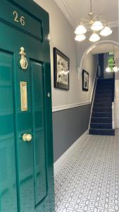 a hallway with a green door and a staircase at Luxury Lakeside Living Broadview 2 Georgian Town House in Enniskillen