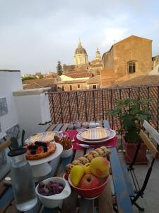 une table avec des assiettes de nourriture sur un balcon dans l'établissement Bed, Book & Breakfast Landolina, à Catane