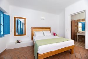 a bedroom with a bed and a bathroom with a sink at Seaside Breeze in Kamari