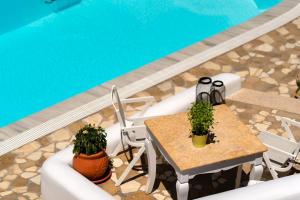 a table and chairs next to a swimming pool at Seaside Breeze in Kamari