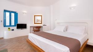a bedroom with a large bed and a television at Seaside Breeze in Kamari