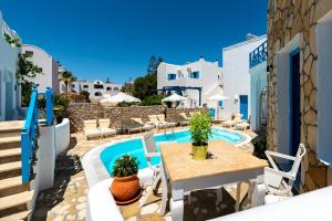 a patio with a table and chairs next to a pool at Seaside Breeze in Kamari
