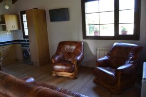 sala de estar con 2 sillas de cuero y sofá en Ruiloba II, en Ribadesella