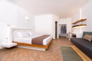 a bedroom with a bed and a couch at Seaside Breeze in Kamari