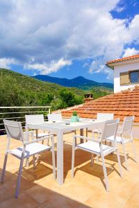 a white dining table and chairs on a patio at Charikleia's country house in Pelion in Volos