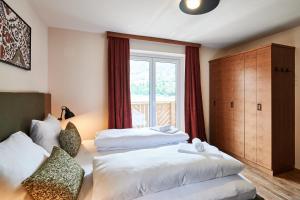 a hotel room with two beds and a window at EVI APARTMENTS via we rent in Kaprun