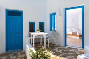 a room with blue doors and a table and a bed at Seaside Breeze in Kamari