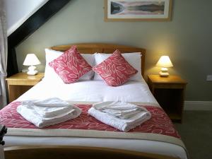 a bed with two pillows and a night stand at The Crown Hotel in Corwen