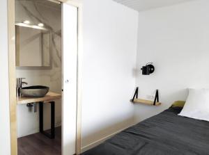 - une chambre avec un lit, un lavabo et un miroir dans l'établissement Mimis House, à Lacanau