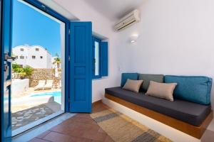 a room with a couch and a sliding glass door at Seaside Breeze in Kamari