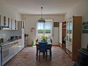 a kitchen with a table and chairs in it at Bnbook Apartment La Motte in Luino