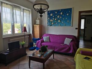 ein Wohnzimmer mit einem lila Sofa und einem Tisch in der Unterkunft Bnbook Apartment La Motte in Luino
