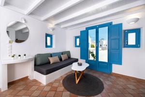 a living room with a couch and a blue door at Seaside Breeze in Kamari
