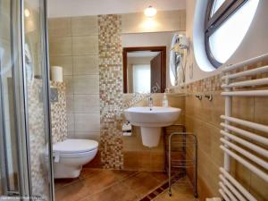 W łazience znajduje się umywalka, toaleta i lustro. w obiekcie Willa Anna w mieście Gdynia