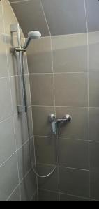 La salle de bains est pourvue d'une douche avec un pommeau de douche. dans l'établissement Vándor Szálló, à Kecskemét