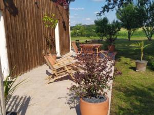 un patio con sillas y una mesa con flores en Gîte Cosy Grand confort dans un écrin de verdure en Agudelle