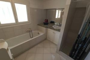 a bathroom with a bath tub and a sink at Location Rez de maison dans quartier charmant in Saint-Raphaël +10 photos