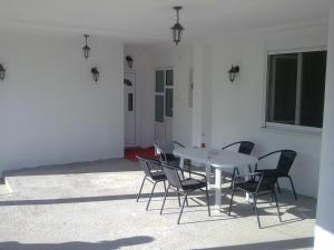 una mesa blanca con sillas y una pared blanca en Apartman Bojovic Sutomore en Sutomore