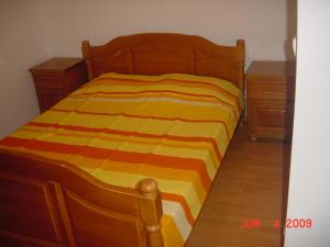 1 cama con manta de rayas naranja y amarilla en Apartman Bojovic Sutomore en Sutomore