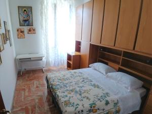 1 dormitorio con 1 cama grande y cabecero de madera en La Romantica, en Levanto