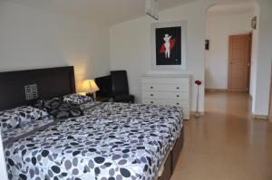 a bedroom with a black and white bed and a dresser at 2021 PRICES!! FAMILY VILLA BY MARINA private pool heating optional, snooker in Benalmádena