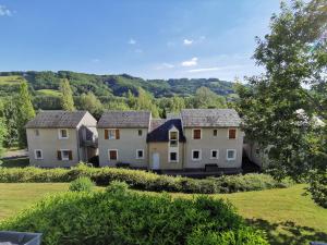 un grupo de casas en un campo con árboles en Au 11 T3 duplex, village vacances, piscines, parking, en Saint-Geniez-dʼOlt