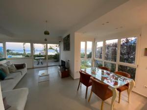 a living room with a glass table and chairs at The Olives Terrace Residences in Dhërmi