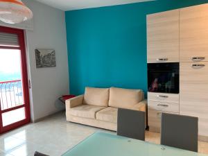 sala de estar con sofá y pared azul en Casa Isabella, en Madonna del Sasso