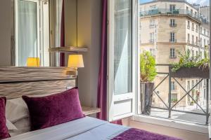 ein Schlafzimmer mit einem Bett und einem großen Fenster in der Unterkunft Louvre Marsollier Opera in Paris