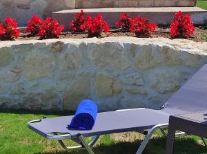 a blue towel sitting on a bench next to a stone wall at Villa Traditional Estate Heated Pool & Garden, 5 bedrooms in Metókhion Patriotikón