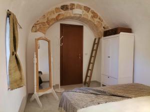 een slaapkamer met een bed, een ladder en een spiegel bij I Trulli dell'Orfanello in Martina Franca