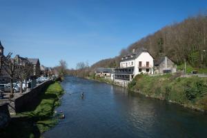 Lortet的住宿－Les chemins du Mont，城镇中拥有房屋和建筑物的河流