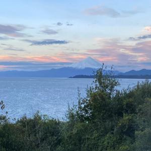 una vista de una montaña en el océano con el cielo en Bordemundo B&B y Cabañas, en Puerto Varas