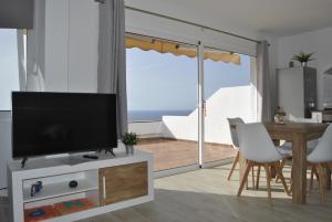ein Wohnzimmer mit einem Flachbild-TV auf einem Stand in der Unterkunft Sunset La Palmita in La Victoria de Acentejo