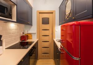a red refrigerator in a small kitchen with a counter at Błękitny Apartament in Bytom