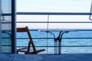 une table et une chaise en face de l'océan dans l'établissement Lemoni Luxury Residence in front of the Sea, à Kekhriaí