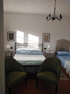 um quarto com uma cama e 2 cadeiras em La Casa Nell'Aia em Monsummano