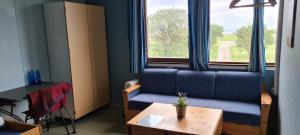 a living room with a blue couch and a table at Solheim Guesthouse in Dverberg