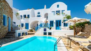 a villa with a swimming pool and white buildings at Seaside Breeze in Kamari