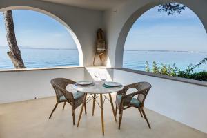 a table and chairs in a room with a view of the ocean at ALCUDIA-VIDA SANA-PRIMERA LINEA DE MAR in Alcudia
