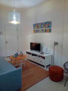 a living room with a couch and a tv at Apartamento Pastora Sevilla in Seville