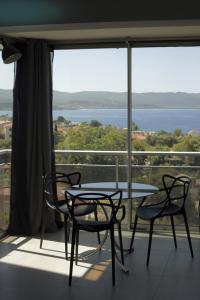 een tafel en stoelen voor een groot raam bij Mare e Vista in Ajaccio